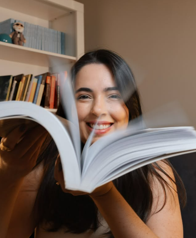 Natália Montalbini sorrindo com um livro nas mãos